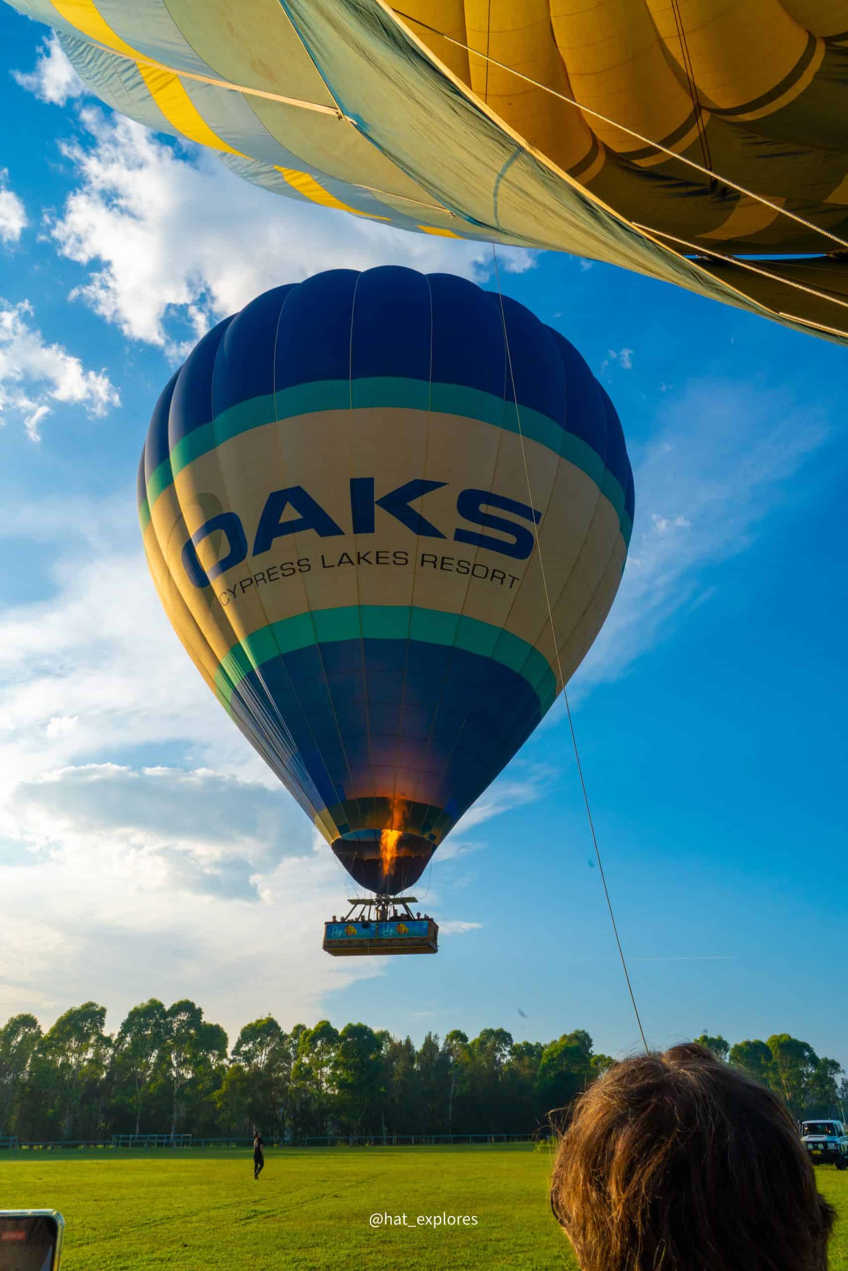 A huge hot air balloon labelled "oaks" landing!