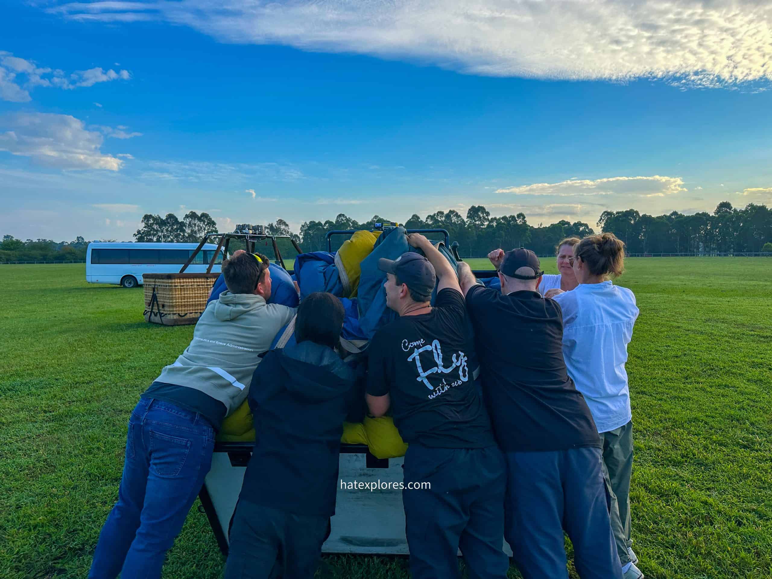 A group of 7-8 people packing the deflated balloon.
