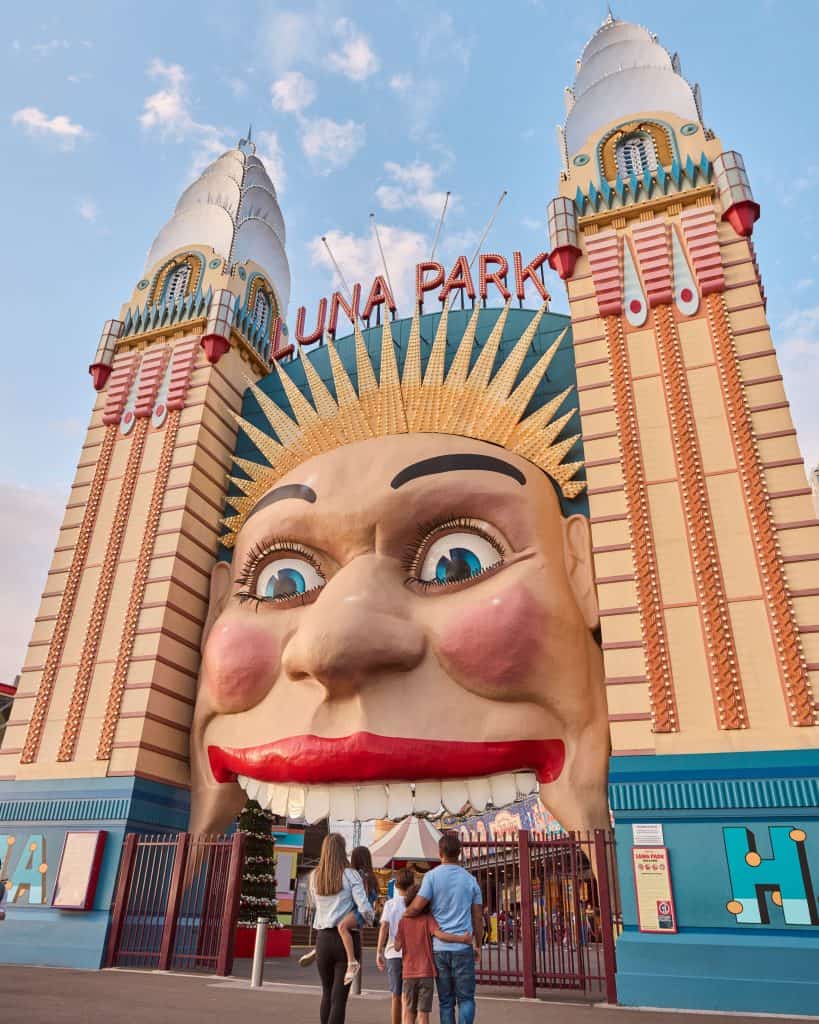 Family walking into Luna Park Sydney, Milsons Point - a fun and iconic attraction among the top Things to Do in November in Sydney.