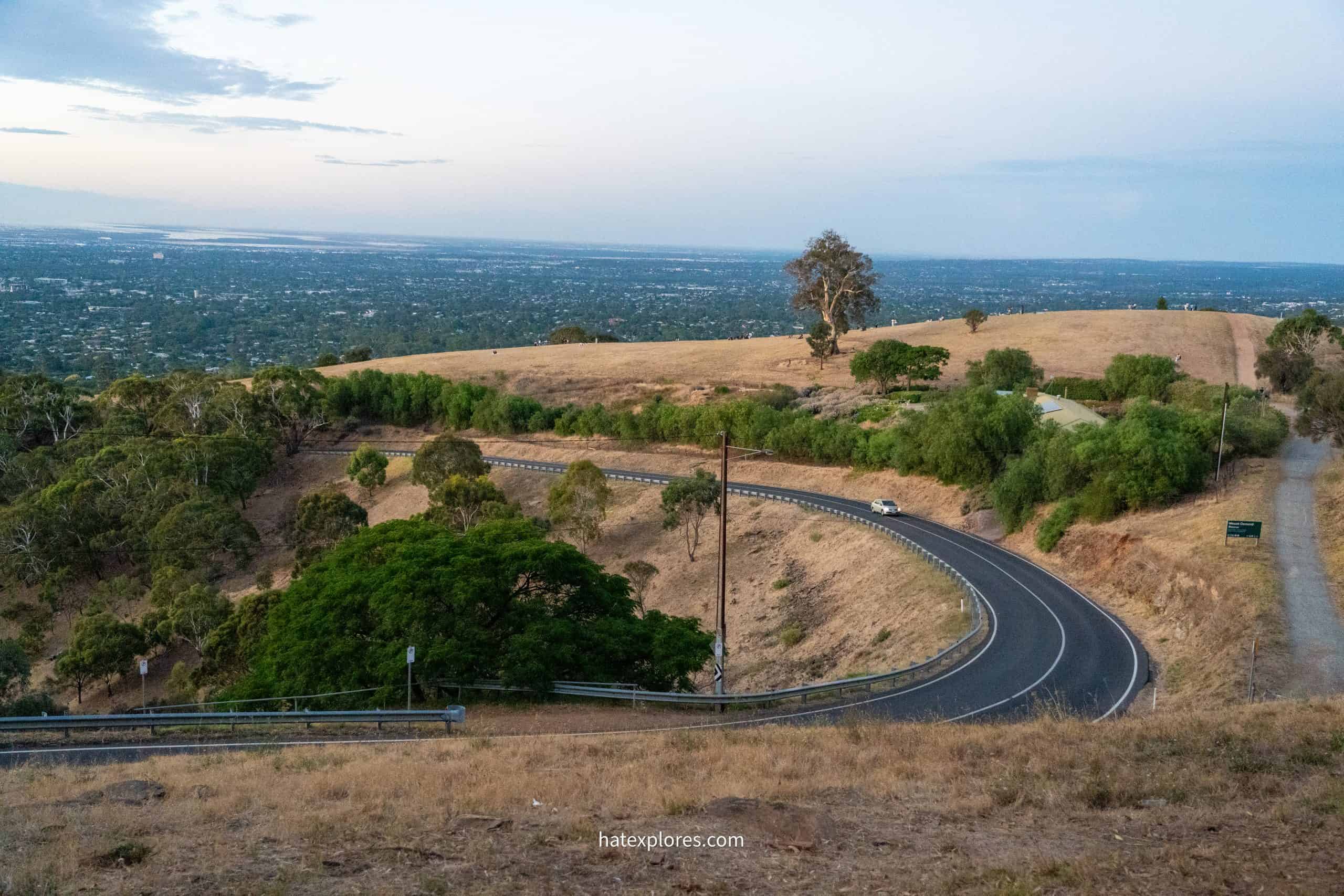 A winding road cuts through dry hills with expansive views of Adelaide in the distance, making Mount Osmond a scenic drive and viewpoint to include in a 3 day Adelaide itinerary.
