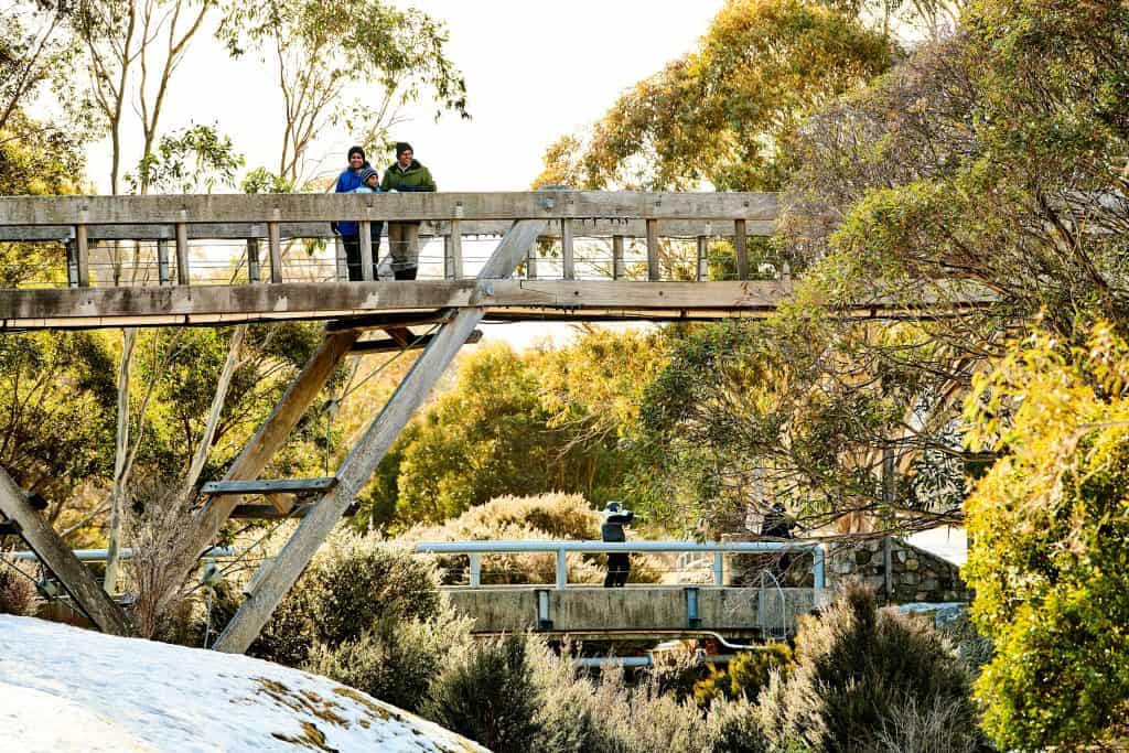 Family crossing the bridge to Thredbo ski resort in the Snowy Mountains.